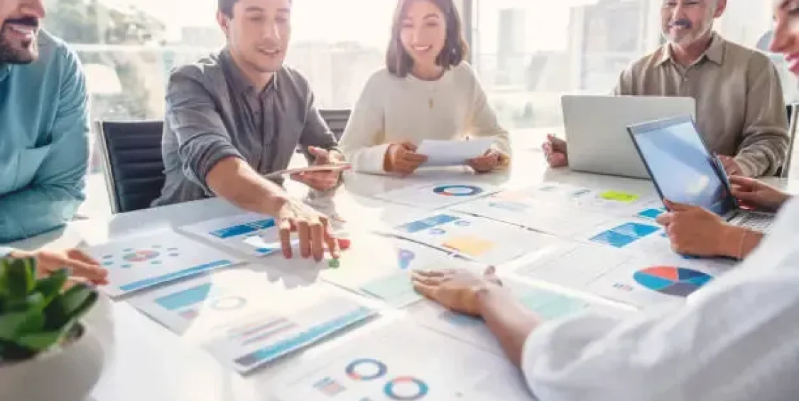 multi-racial-diverse-group-of-people-working-with-paperwork-on-a-board-room-table-at-a